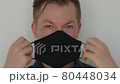 Portrait of man taking face mask off and smiling 80448034