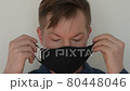Portrait of man putting face mask on 80448046