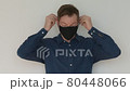 Portrait of man putting face mask on 80448066