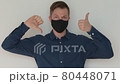 Portrait of man thinking positive and negative sides of face mask wearing 80448071