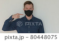 Portrait of man pointing finger to face mask and giving thumbs up 80448075