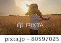 Happy kid playing with toy airplane at sunset over wheat field. Kid dreams of becoming an astronaut pilot. Children's dream to run with toy. Kid airplane pilot. Dream concept and happy family. 80597025