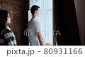 Young couple man and woman stay near window at home. Happy young lovers enjoy time spending together at home 80931166