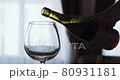 Close-up of filling wine glass with red wine in super slow motion. Pouring red wine into goblet. Red wine forms beautiful wave in glass 80931181