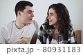A happy couple man and woman are eating pizza in a bed at home. Happy young lovers enjoy time spending together 80931183