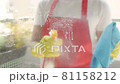 Female hands in yellow gloves cleaning window pane with rag and spray detergent. Cleaning conceptWashing windows with spray. 81158212