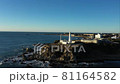 早朝の朝日を浴びる岬の先の白い灯台 81164582