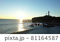 早朝の朝日を浴びる岬の先の白い灯台 81164587