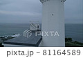 早朝の朝日を浴びる岬の先の白い灯台 81164589