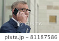 Portrait of a senior businessman talking with a smart phone outside of modern office building. Successful business man. 81187586