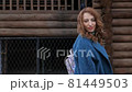 young red-haired woman in a blue coat and walks against the backdrop of the old city. portrait of a beautiful woman in the autumn city 81449503