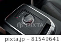 The man's hand switches gears in the car.  81549641