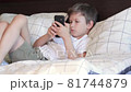 Cute child talking by video call on smartphone while lying in bed 81744879