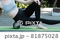 Sports girl massages the muscles of the thigh with myofascial roller. Fascia release. 81875028