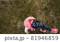 Active little girl doing backbend on green grass 81946859