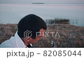 Alone man playing guitar sitting on the coast 82085044