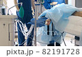 Plastic surgery. Female specialist in surgical mask on face perform operation with medical tools. Teamwork of surgeons in the operating room. 82191728