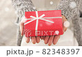 ギフトボックスを差し出す　粉雪が降る冬に 82348397