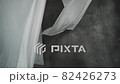 White fabric sheets are dried on clothespins on a rope. The wavy fabric sways in the wind. Abstract gray background. 82426273