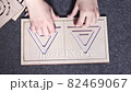 Teenager girl hands changing stencils in symmetrical double-sided triangular maze stencil made of wood 82469067