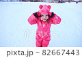 Child on a winter walk. Little girl running in the snow in winter. Winter fun. Child playing in the park in winter 82667443