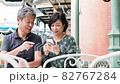 Senior couple meeting on the terrace and having a fun conversation while looking at their smartphones 82767284