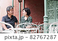 Senior couple meeting on the terrace and having a fun conversation while looking at their smartphones 82767287