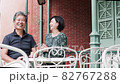 Senior couple meeting on the terrace and having a fun conversation while looking at their smartphones 82767288