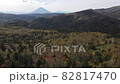 A mountain with a beautiful ridgeline that emerges beyond the primeval forest where the autumn leaves have advanced. 82817470