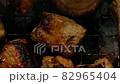 Mushrooms and meat grilling on a barbecue, top view 82965404