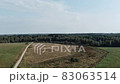 Aerial panorama of rural road passing through agricultural land and pasture fields in Latvia 83063514