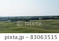 Aerial panorama of rural road passing through agricultural land and pasture fields in Latvia 83063515