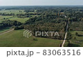 Aerial panorama of rural road passing through agricultural land and pasture fields in Latvia 83063516