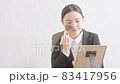 鏡を見ながらメイクをするスーツ姿の若い女性 83417956