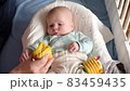 Baby boy playing with a toy on a bed at home 83459435