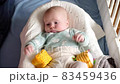 Baby boy playing with a toy on a bed at home 83459436