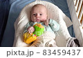 Baby boy playing with a toy on a bed at home 83459437