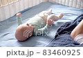 Father checking diaper of son at bed 83460925