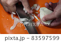 Slicing or cutting onion with sharp knife. 83597599