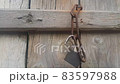 Hanging lock with iron chain from a wooden door 83597988