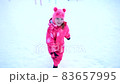 Little girl running in the snow in winter. Winter fun. Child playing in the park in winter 83657995
