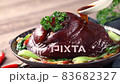 Pouring savory soy sauce with spoon over Taiwanese braised pork hock food in a plate. 83682327