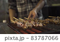 Hong Kong chef turns kebabs and spreads sauce on grill 83787066