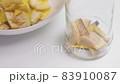 A person making banana peel fertilizer with banana cuts. Putting small pieces of banana skin into the glass jar and pouring water 83910087