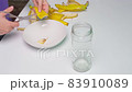 A person making banana peel fertilizer with banana cuts. A woman hand cutting banana skin into small pieces 83910089