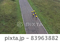 Five cyclists in sports yellow clothes ride along the track on bicycles, professional training. Aerial 83963882