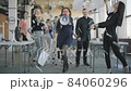 Creative office team. A woman chief accountant takes a megaphone and shouts at him. Employees get up from their seats, dance and have fun. Positive festive atmosphere. 84060296