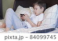 Boring kid playing game on smart phone 84099745