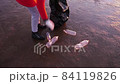 A woman cleans the bank of plastic bottles and puts the trash in a garbage bag. Environmental pollution by plastic. Recyclable packaging. 84119826