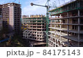 Workers and cranes on the building construction complex 84175143